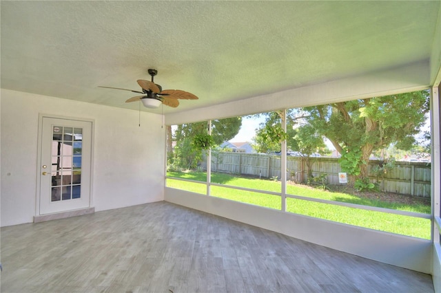 unfurnished sunroom with ceiling fan