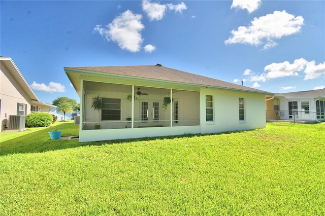 back of property with central air condition unit, ceiling fan, and a yard