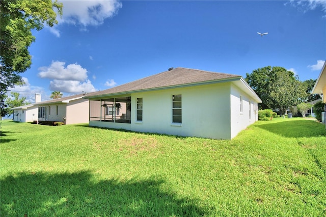 back of house with a lawn and stucco siding