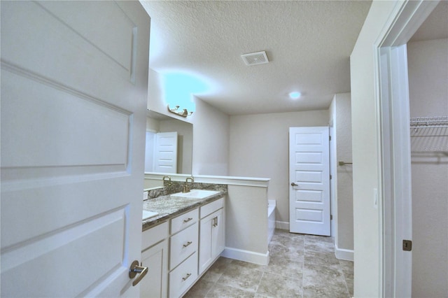 bathroom featuring vanity, a textured ceiling, and a tub to relax in