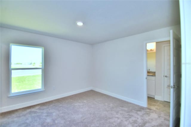 unfurnished room with light colored carpet and a wealth of natural light