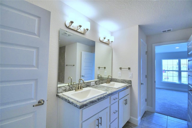 bathroom with tile patterned floors, vanity, and a textured ceiling