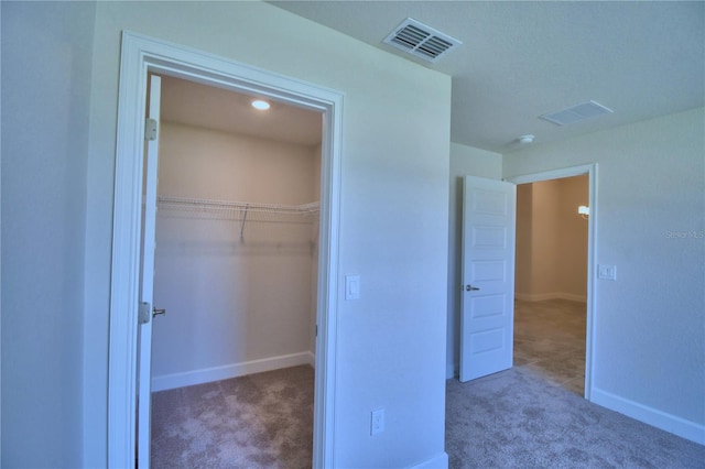 unfurnished bedroom featuring light colored carpet and a closet