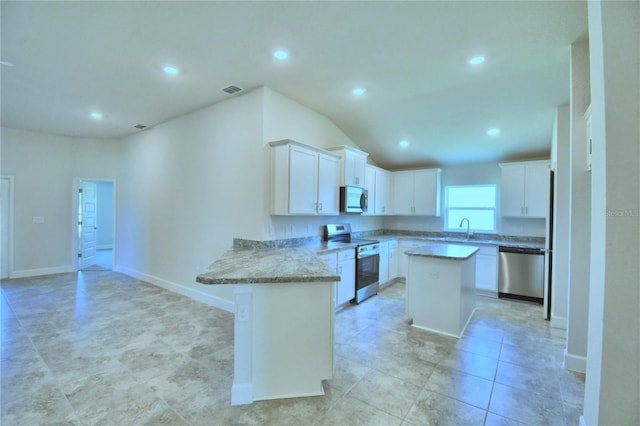 kitchen featuring sink, a kitchen island, kitchen peninsula, white cabinets, and appliances with stainless steel finishes