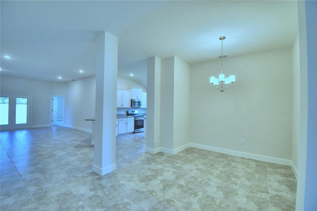 spare room featuring french doors and an inviting chandelier