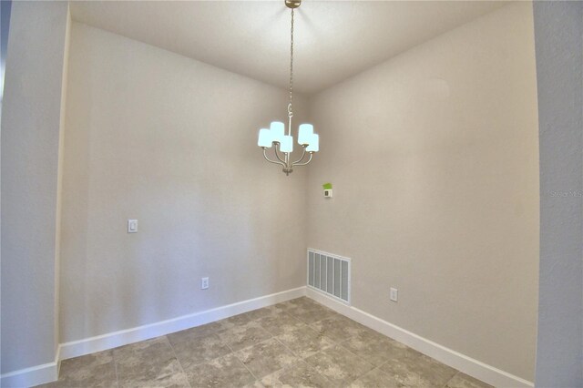 unfurnished room with a chandelier