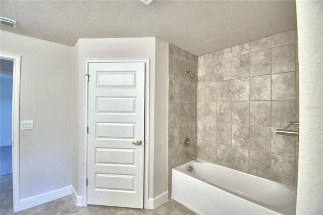 bathroom featuring a textured ceiling, tile patterned floors, and tiled shower / bath