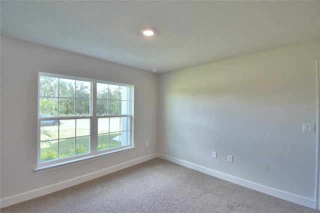 carpeted spare room featuring plenty of natural light