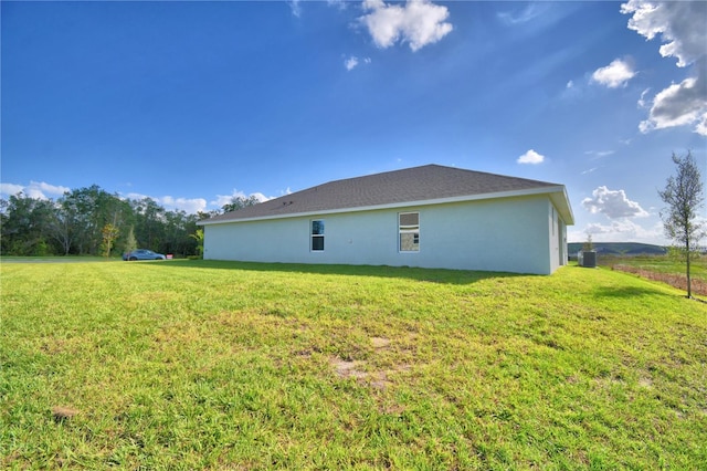 view of home's exterior with a lawn and central AC