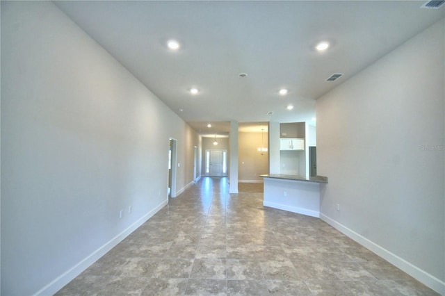 unfurnished living room featuring a notable chandelier