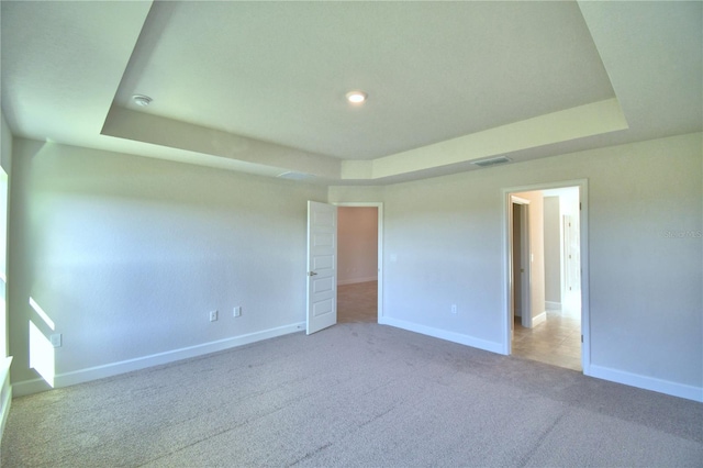 unfurnished bedroom with carpet and a raised ceiling