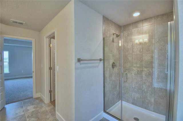 bathroom featuring tile patterned flooring and a shower with shower door