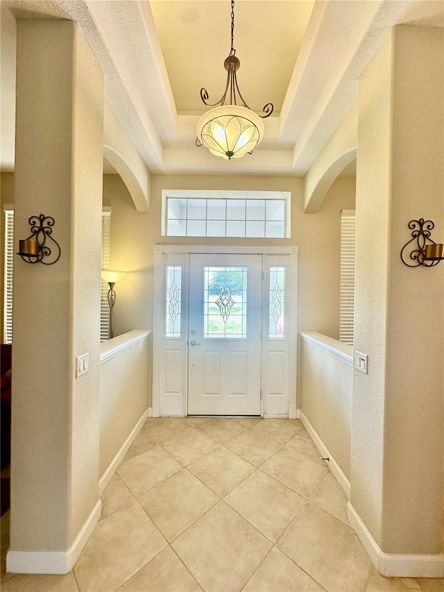 entrance foyer with light tile patterned flooring and a raised ceiling