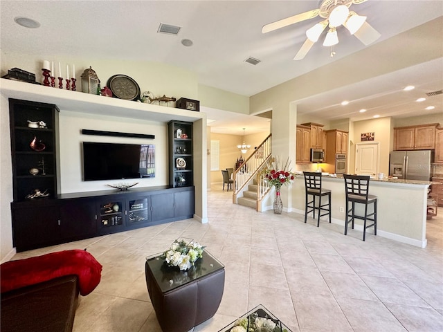 tiled living room featuring ceiling fan with notable chandelier