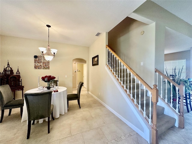 tiled dining room featuring a notable chandelier