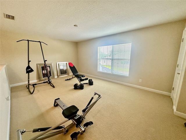 exercise area featuring carpet and a textured ceiling