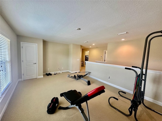 exercise area with carpet and a textured ceiling