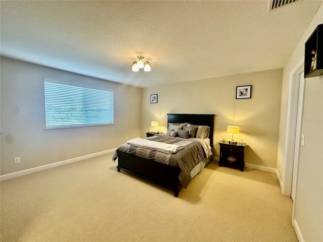 bedroom featuring light colored carpet and a textured ceiling