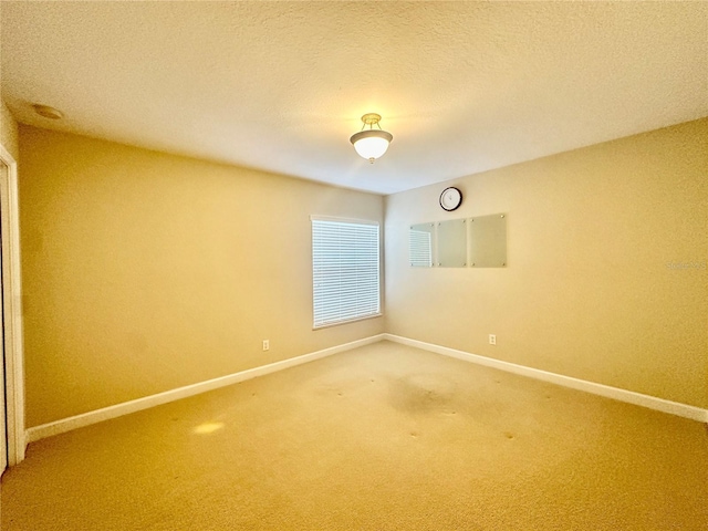 spare room featuring carpet floors and a textured ceiling