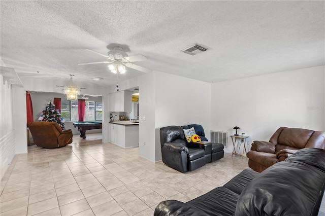 tiled living room with a textured ceiling, ceiling fan, and pool table