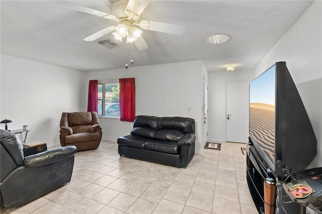 tiled living room featuring ceiling fan and a textured ceiling