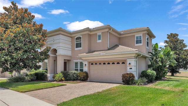 mediterranean / spanish house with a garage and a front lawn