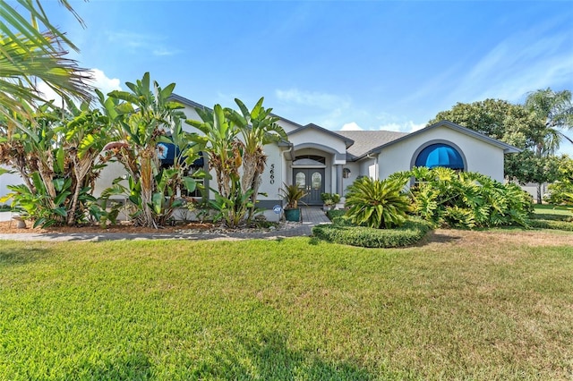 view of front of property featuring a front yard and french doors