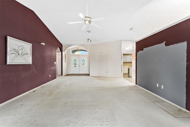 unfurnished living room with ceiling fan, french doors, light colored carpet, and lofted ceiling