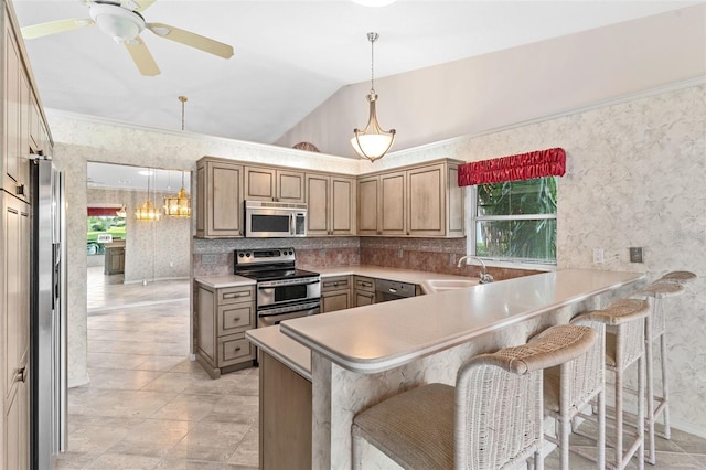 kitchen with plenty of natural light, a kitchen bar, kitchen peninsula, and stainless steel appliances