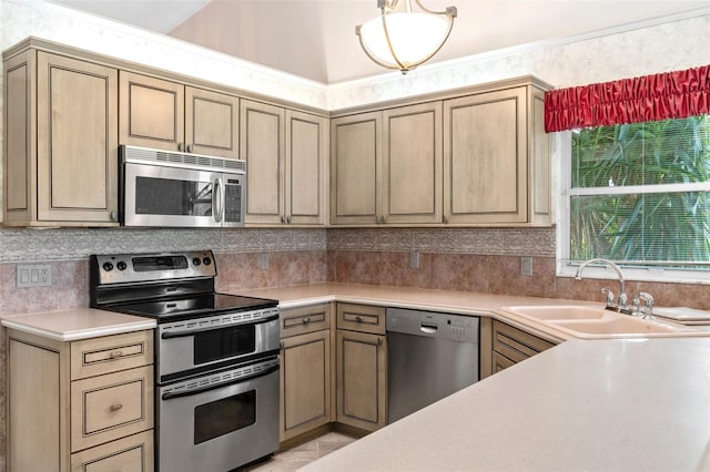 kitchen featuring decorative backsplash, lofted ceiling, sink, and appliances with stainless steel finishes