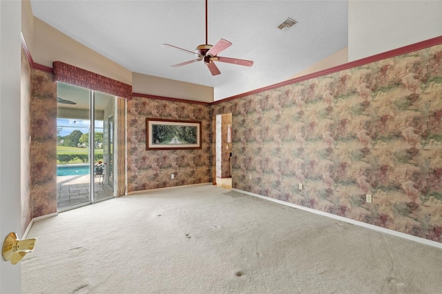 empty room featuring a textured ceiling, ceiling fan, carpet floors, and lofted ceiling