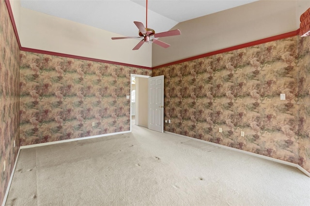 spare room featuring carpet, vaulted ceiling, and ceiling fan