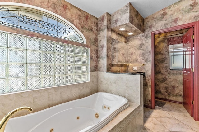 bathroom featuring tile patterned flooring, tiled bath, and plenty of natural light