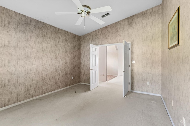 carpeted spare room featuring ceiling fan