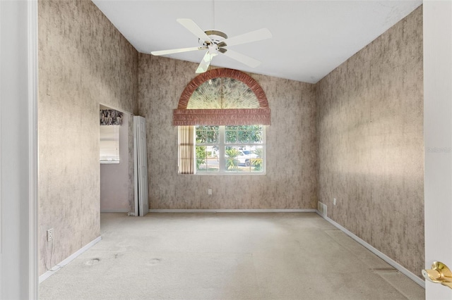 carpeted empty room with ceiling fan and lofted ceiling