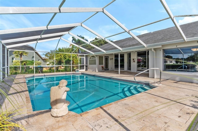 view of swimming pool featuring glass enclosure and a patio area