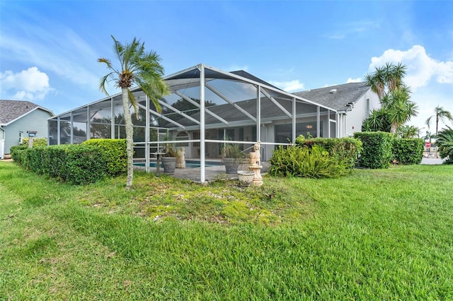 back of house featuring a lanai and a lawn