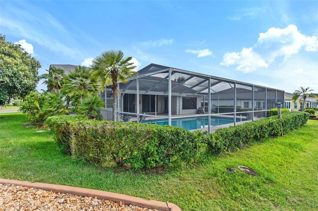 view of pool featuring a lawn and glass enclosure