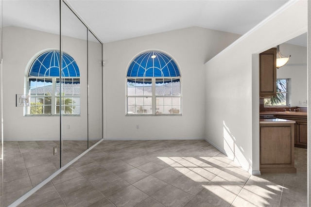 unfurnished bedroom featuring tile patterned floors, sink, and vaulted ceiling