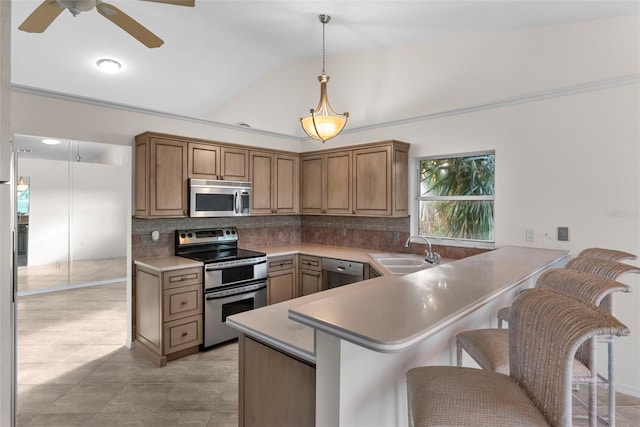 kitchen with appliances with stainless steel finishes, sink, a breakfast bar area, hanging light fixtures, and kitchen peninsula