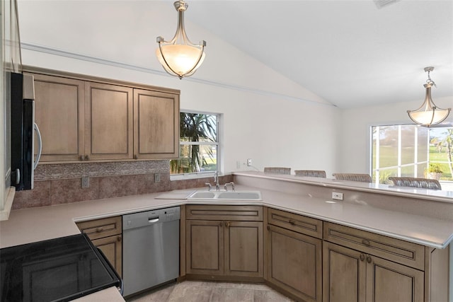 kitchen featuring lofted ceiling, sink, decorative light fixtures, and appliances with stainless steel finishes