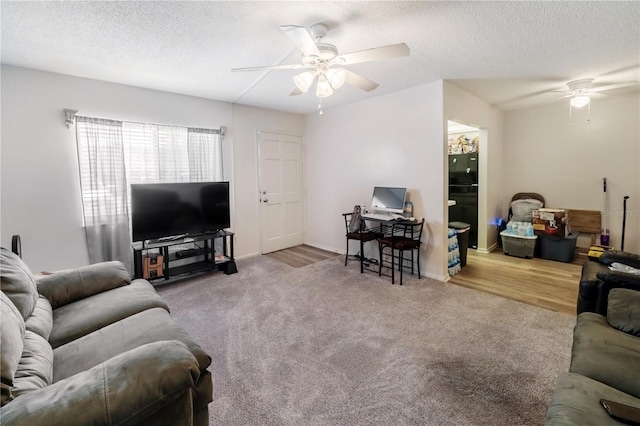 carpeted living room featuring ceiling fan and a textured ceiling