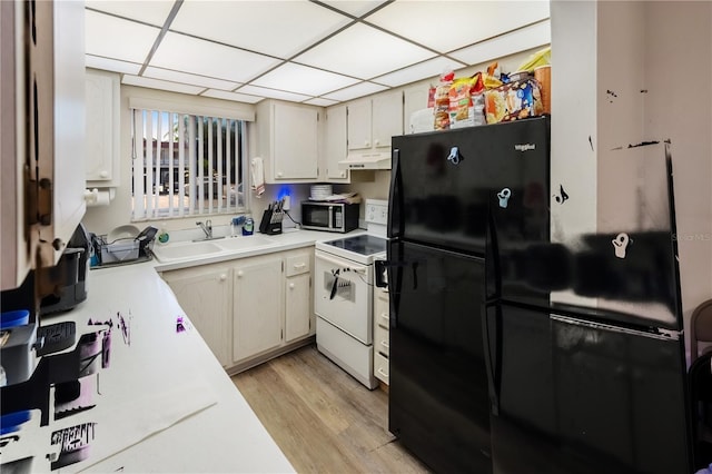 kitchen with black refrigerator, electric stove, a paneled ceiling, light hardwood / wood-style flooring, and sink