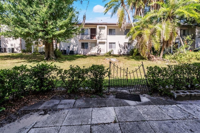 exterior space featuring a front lawn and a balcony