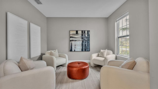 living area with plenty of natural light and hardwood / wood-style flooring