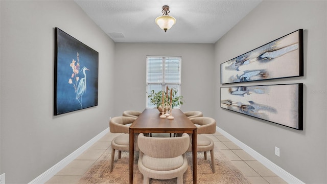 dining room with light tile patterned floors and a textured ceiling