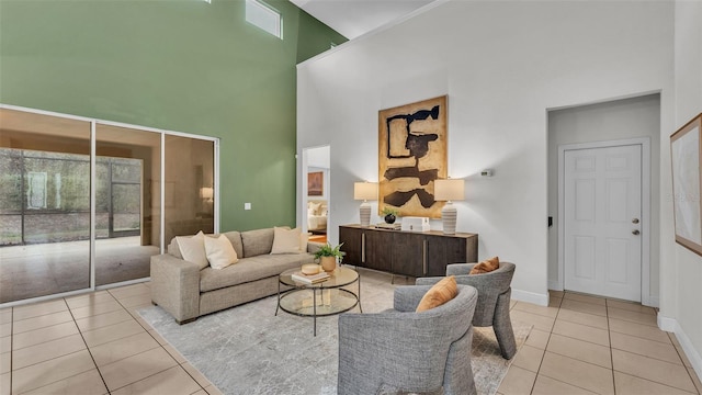 living room with a towering ceiling and light tile patterned floors