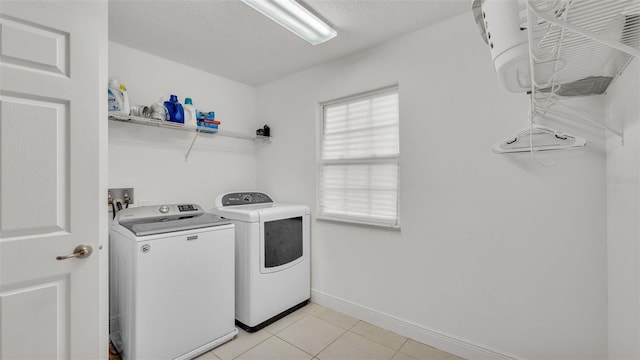 laundry room with washer and dryer, light tile patterned floors, and a textured ceiling