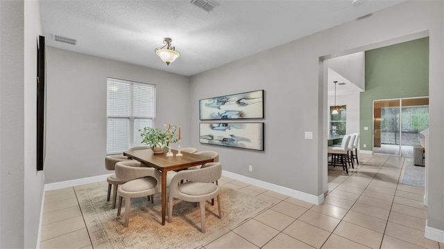 tiled dining area featuring a textured ceiling