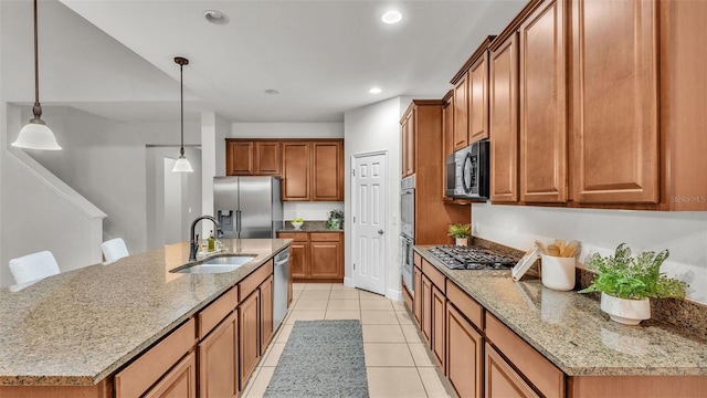 kitchen featuring pendant lighting, a kitchen island with sink, sink, and appliances with stainless steel finishes